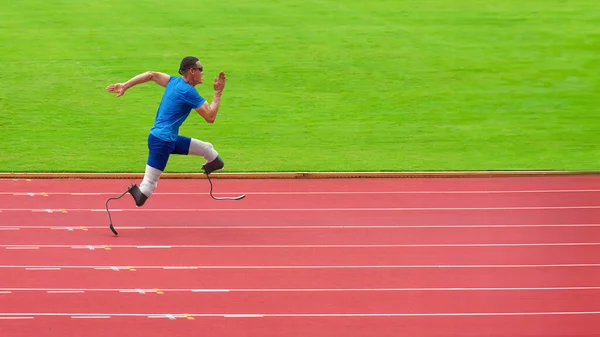 a resilient asian paralympic athlete, equipped with prosthetic running blades, can be seen intently training on an athletic track situated in a sports stadium.