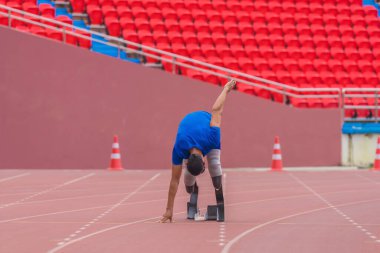 Başlangıç bloğunda Asyalı atlet, protez koşu bıçaklarıyla stadyum pistinde hızlı koşmaya hazır.