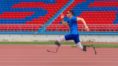 İnatçı Asyalı sporcu, protez bıçaklarla rekorunu kırmak için stadyum pistinde hızlanıyor.