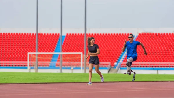 Asian female trainer, male athlete with prosthetics jog together, warming up before speed run at stadium