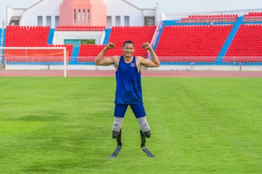 Protez takan Asyalı sporcu, Tayland 'ın takım üniformasını stadyumda sergiliyor.