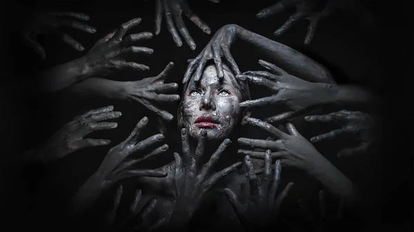 어두운 배경에서 악마의 손으로 둘러싸인 무서운 얼굴의 메이크업의 할로윈 — 스톡 사진