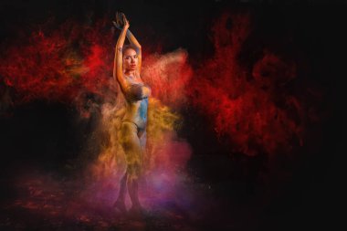 Bikinili Asyalı kadın dansçı dinamik poz veriyor, vücudu Holi festivali kutlamalarını hatırlatan çok renkli tozlarla süslenmiş.