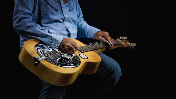 Zbliżenie Gitary Dobro Spoczywającej Kolanach Muzyka Ubranego Kowbojskie Stroje Ciemnym — Zdjęcie stockowe