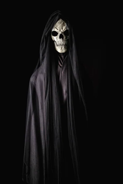 黒いガウンに描かれた頭蓋骨の顔を持つ悪魔の冷たい肖像画は ピッチダークの背景に不吉にローミングし ハロウィーンの本質をカプセル化 — ストック写真