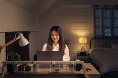 Düşünceli kadın profesyonel işine dalmış, sessiz gece saatlerinde ev ofisinde stratejiler tasarlıyormuş.