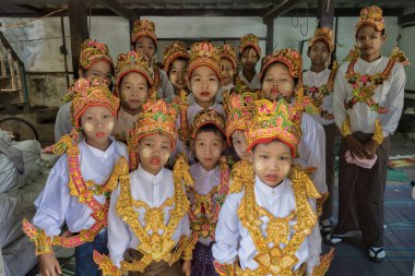 Pyay, Myanmar, 4 Mart 2023: Geleneksel Myanmar elbisesi giymiş bir grup çocuk Budist acemi olmak için Budist Paskalya Perhizi 'nin önünde toplandı.