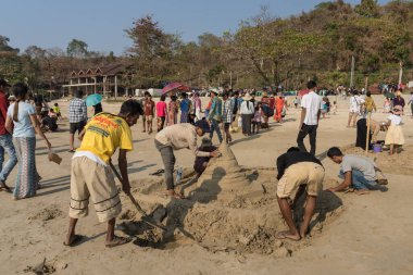 Ngapali plajı, Rakhine, Myanmar, Mart 2023: Ngapali Sonbahar Festivali 'ne katılanlar sahildeki geleneksel kum heykeli sanatıyla ilgileniyorlar