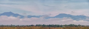 Myanmar, Kachin eyaletinin çimenli ovalarından görülebileceği gibi, sisli ve dingin dağların panoramik görüntüsü.