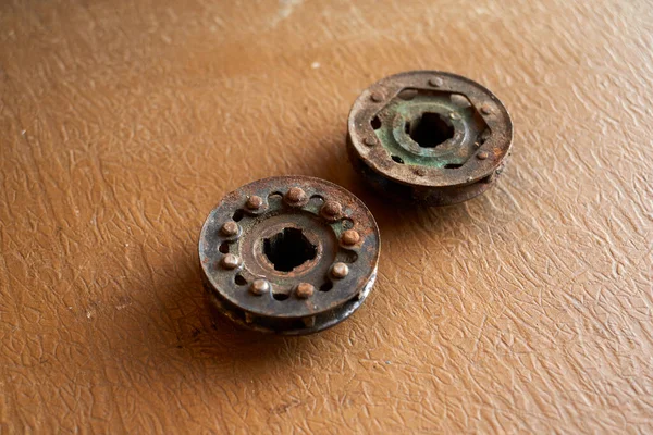 Photo of two rusty chainsaw sprockets on the table