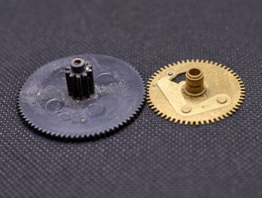 Plastic and brass gears on black background