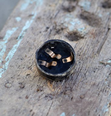 Headlight plastic cover with brass contacts on a wood