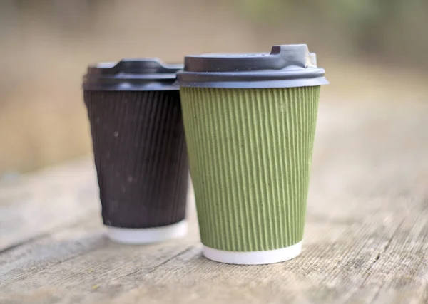 Two paper coffee cups on blurred background