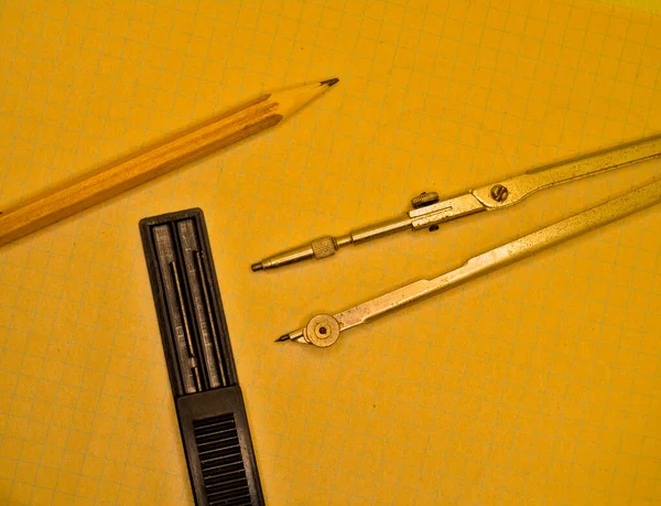 笔记本上用于绘图 铅笔和石墨棒的指南针 — 图库照片