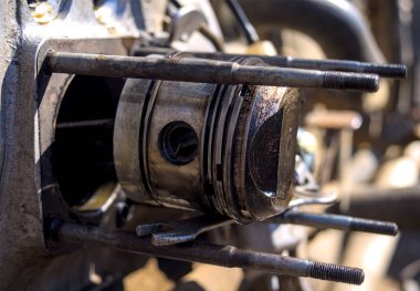 Parçalanmış motosiklet motorunun yüzükleriyle birlikte tabanca.