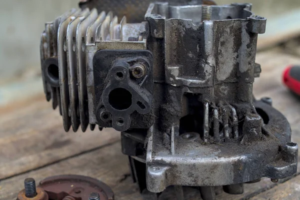 Photo of broken trimmer engine covered by oil and dirt