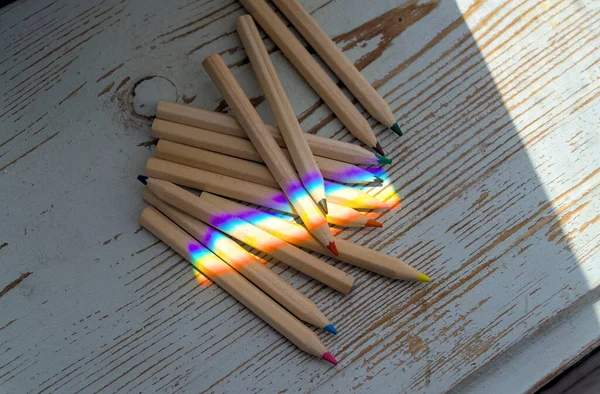 Bleistifte Unter Regenbogenfarbe Sonnenstrahl Auf Holzplanke — Stockfoto