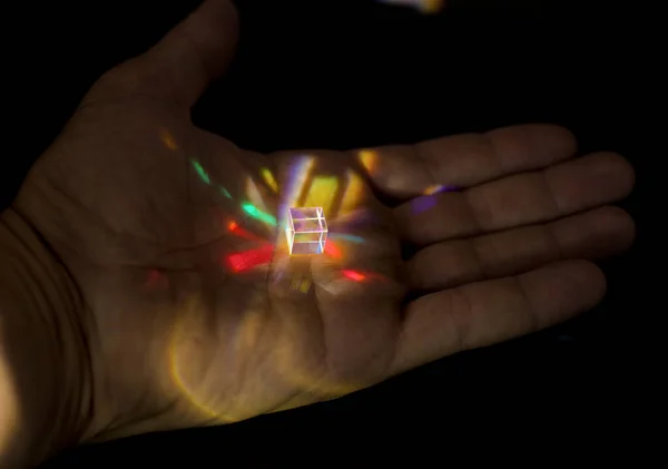 人間の手に光の反射を持つガラス結晶の写真 — ストック写真