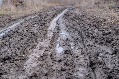 Şubat ayında ıslak ve çamurlu bir köy yolu. Ukrayna.