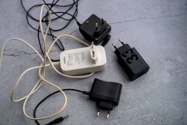 Gri arkaplanda siyah beyaz cep telefonu şarj cihazları