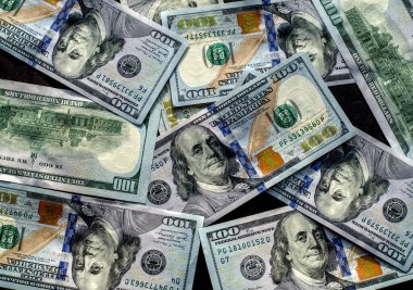 Masada 100 dolarlık kağıt para yatıyor. 100 Amerikan dolarına yakın çekim.