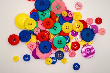 Renkli düğmeler, çeşitli boyut, renk ve tasarımlar sergiliyor. Dikiş ve el işi için ideal.