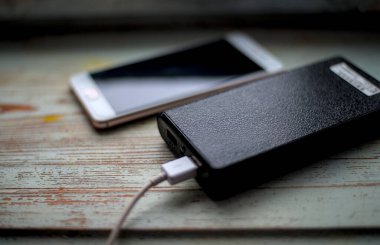 Mobil batarya ahşap masada şarj oluyor.