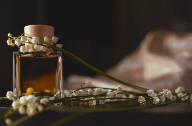 Bir şişe parfüm ve narin çiçekler.