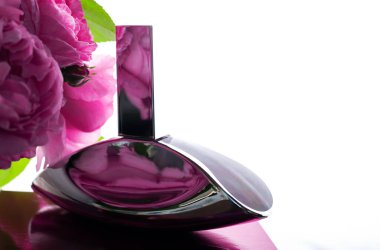 Parfüm şişesi ve pembe çiçekler