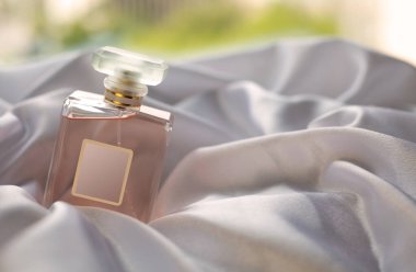 Beyaz saten üzerinde lüks bir parfüm