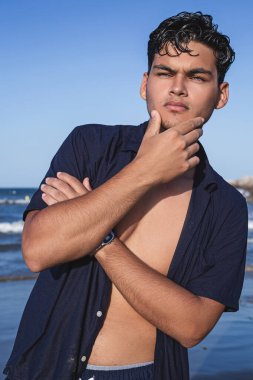 Deniz kıyısındaki yakışıklı bir gencin portresi.