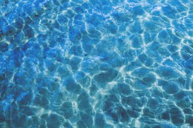 Yüzeyinde hafif dalgalanmalar ve kırılan ışık ile okyanusun mavi yüzeyi.