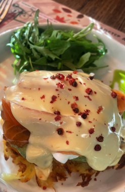 Üstünde somon ve haşlanmış yumurta olan patates kızartması yığını.