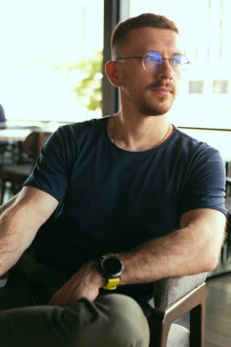 Genç işadamı rahat oturuyor.