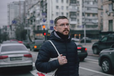 Genç bir adam şehirde dolaşıyor.