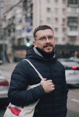 Genç bir adam şehirde dolaşıyor.