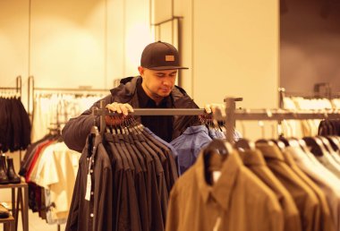 Giyim mağazasındaki genç adam.