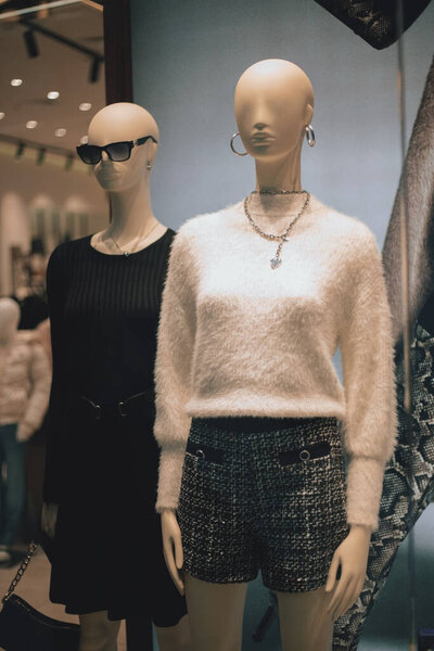Female mannequins in stylish clothes in a shop window