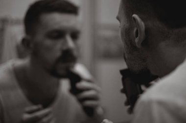 Tıraş olan bir adamın siyah beyaz fotoğrafı.