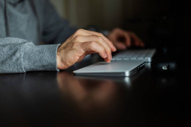 Masada yeni bir iş projesi üzerinde çalışırken dizüstü bilgisayar başında genç ofis yöneticisinin elleri