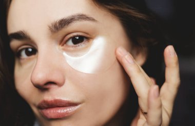 Mükemmel yumuşak ciltli güzel bir kadın kendine kozmetikle bakıyor.