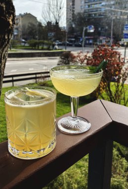 Ahşap arka planda iki tane sarı kokteyl.