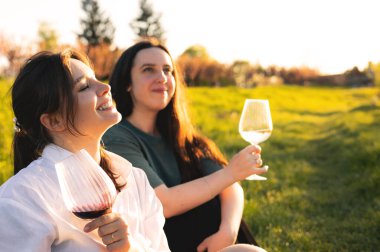 Güzel kızlar gün batımında şarap içiyor.