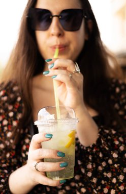 Genç bayan yazın soğuk limonata içiyor.