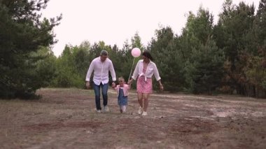 Küçük çocuklu mutlu bir aile parkta eğleniyor.