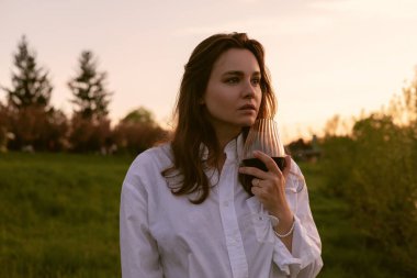 Gün batımında şaraplı güzel bir kadın