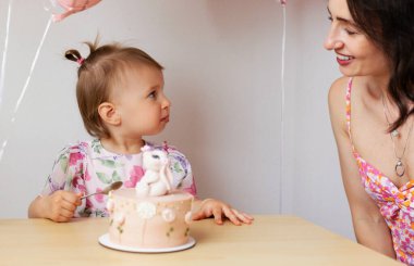 İki yaşında bir kız doğum günü pastası yiyor.