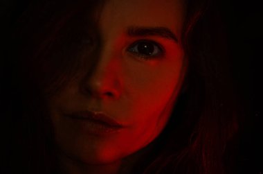 Kırmızı tonlarda bir kadın yüzü silueti.