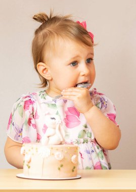 Çocuk doğum günü pastası yiyor.