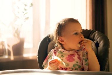 yüksek sandalyede oturan kız bebek